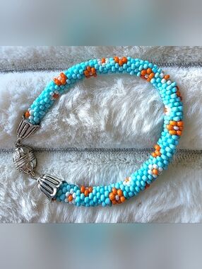 Artisan made Sead bead rope bracelet Of light blue, orange, and white floral